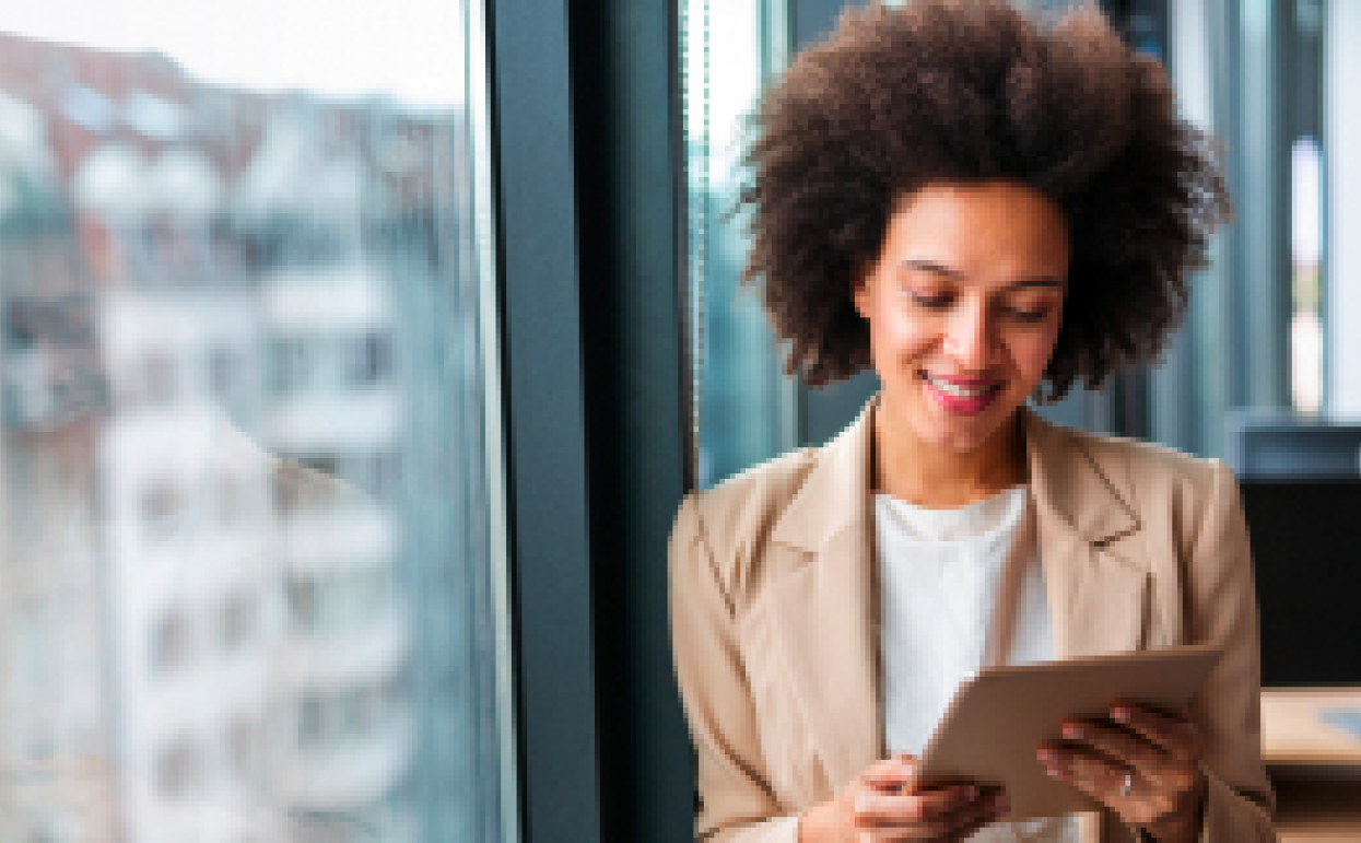 Mujer con chaqueta marron leyendo en tablet