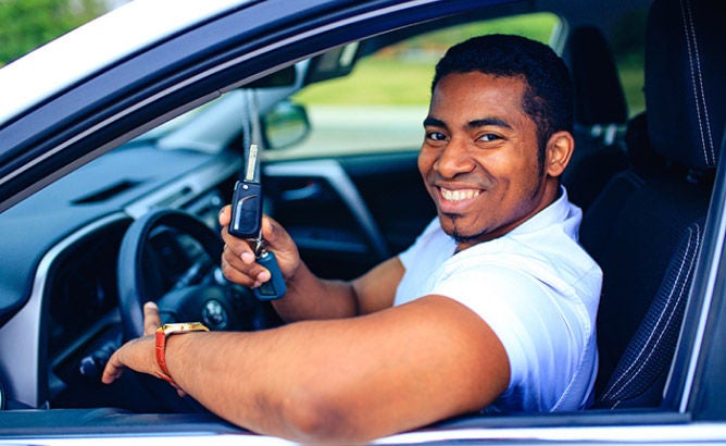 man smiling inside a car