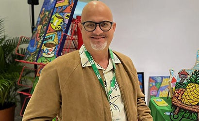 Banner promocional que muestra a una persona frente a una obra de arte colorida.