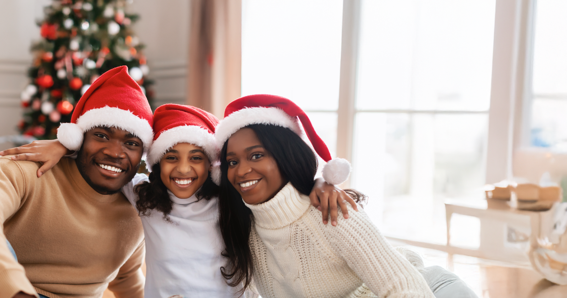 familiy  smiling in front of a chistmas tree