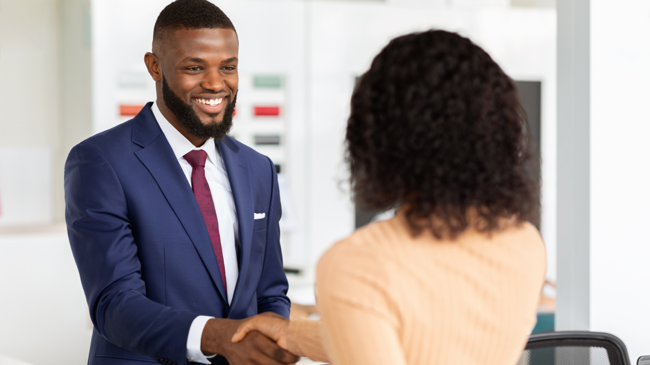 Man in blue jacket greeting woman