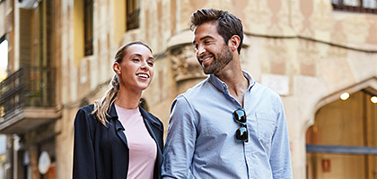 Pareja sonriendo caminando en una calle