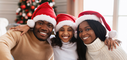 familiy  smiling in front of a chistmas tree