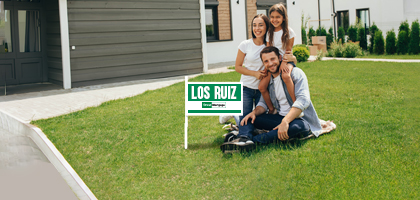 familia sonriendo sentada de lado de un letrero de vendido