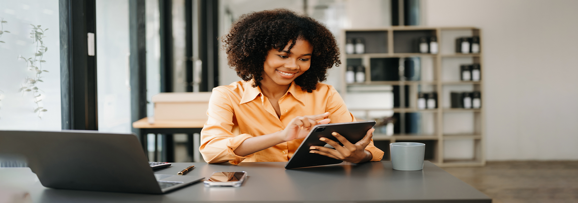 Mujer de negocios usando la tableta y el ordenador portátil para hacer finanzas matemáticas en un escritorio de oficina.